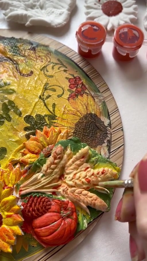 A sunflower, wheat and small pumpkins gathered on an autumn-coloured tray